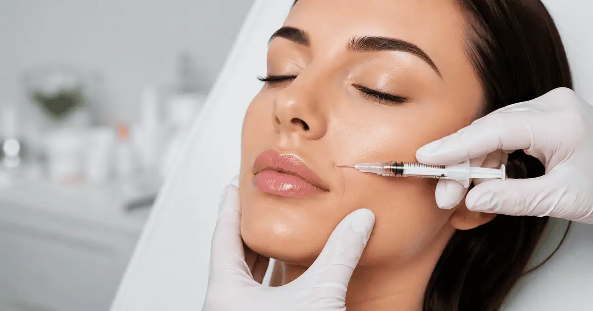 Woman receiving dermal filler treatment during facial consultation